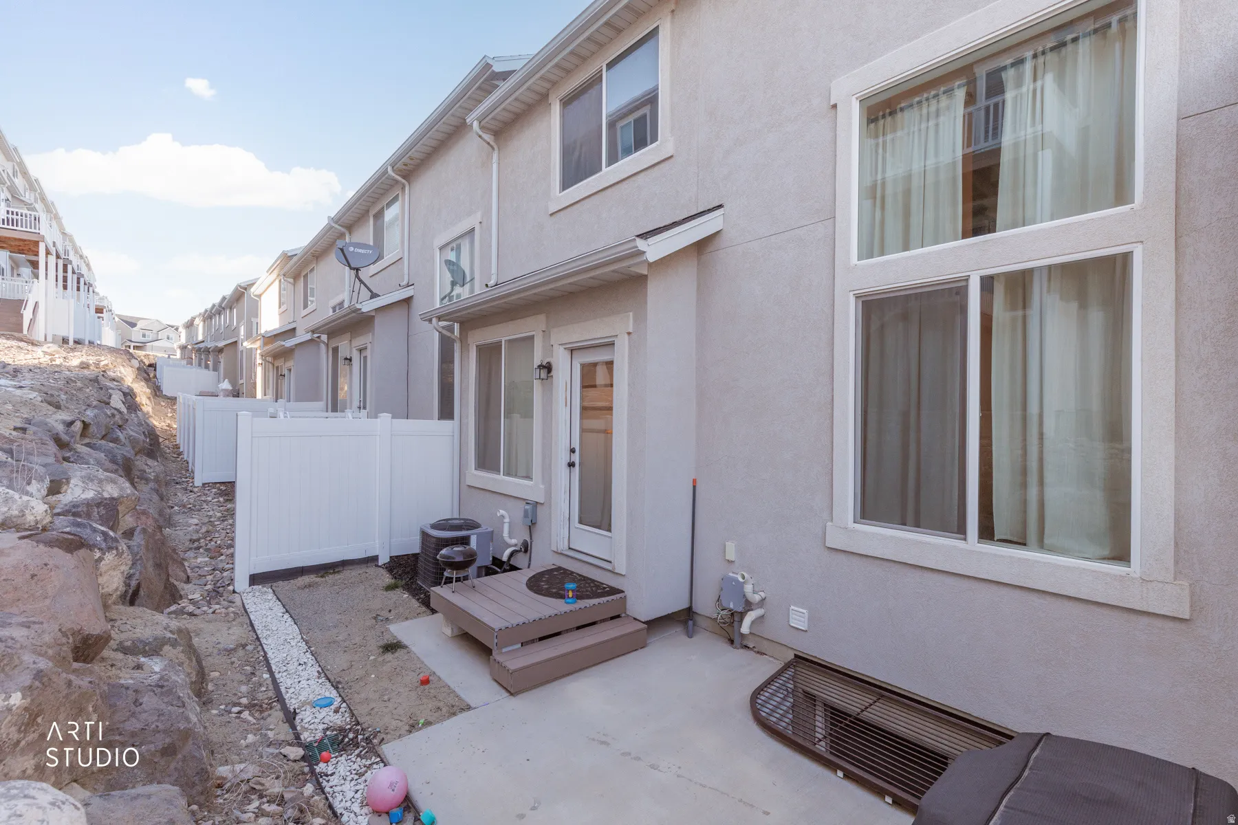 View of exterior entry featuring stucco siding and a patio area