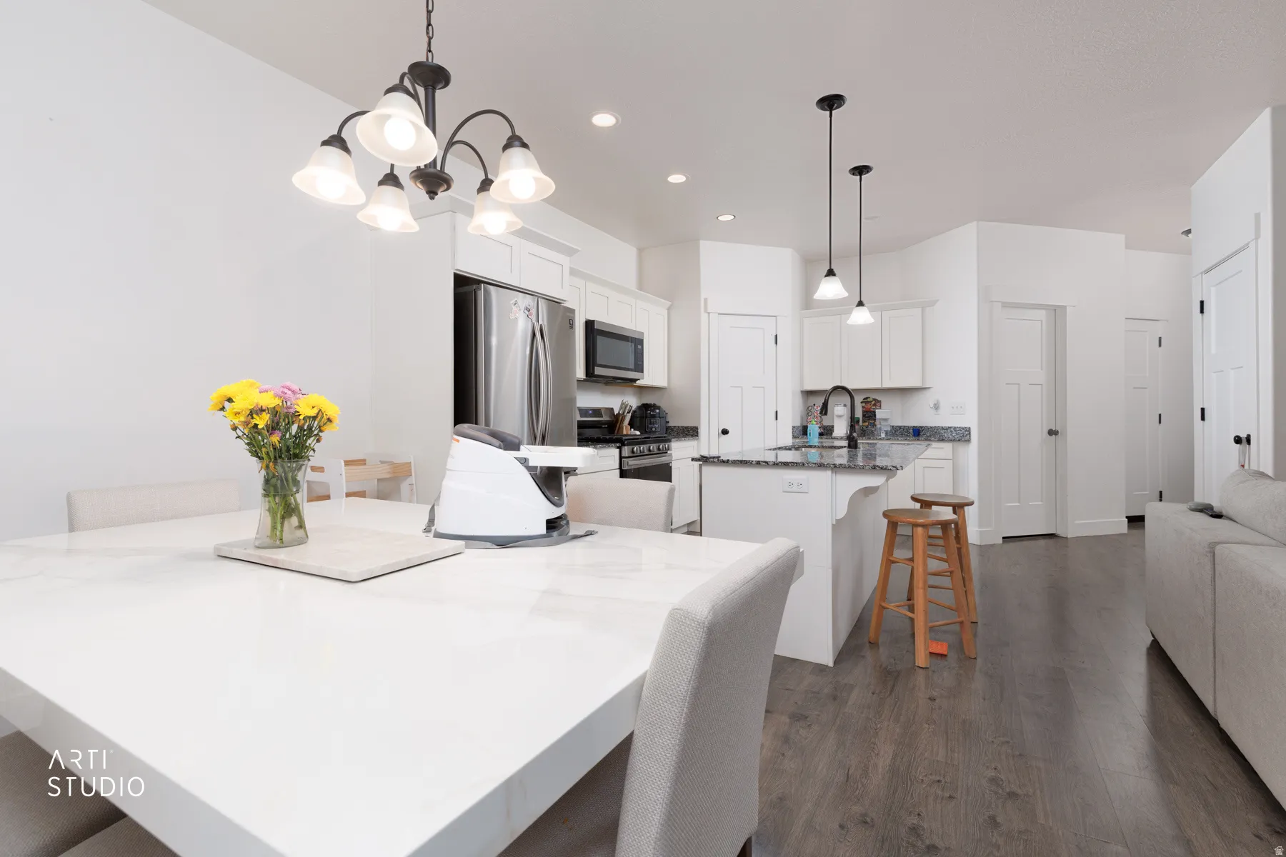 Dining space with dark wood-type flooring and hanging lights