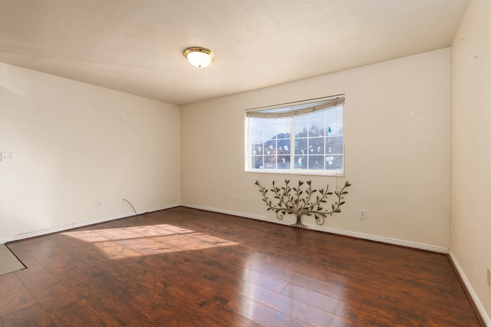 Unfurnished room with hardwood / wood-style floors and a textured ceiling
