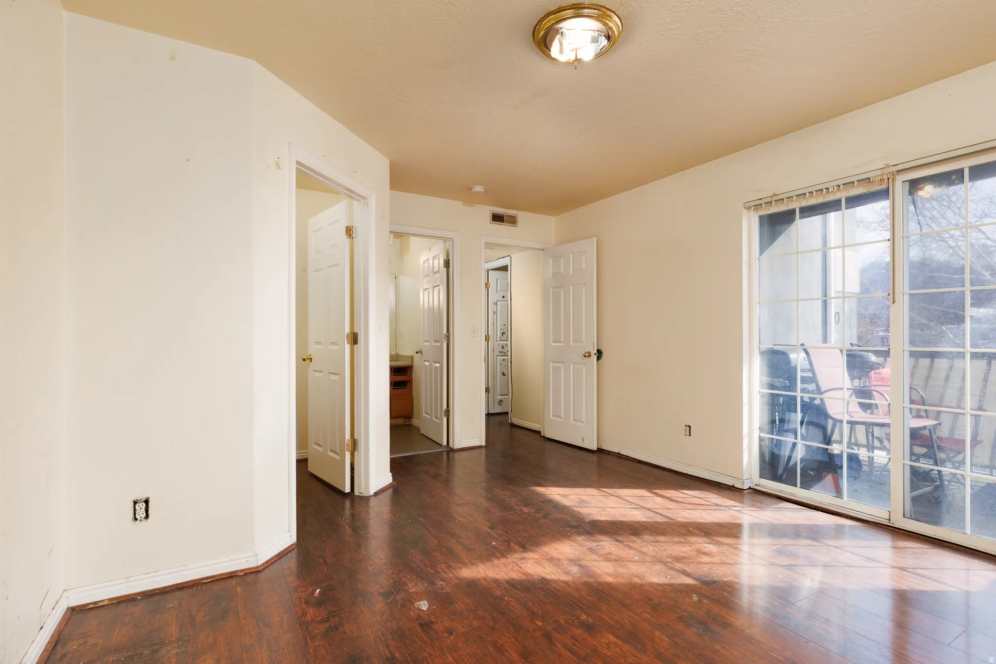 Unfurnished bedroom featuring dark wood-style flooring and access to outside