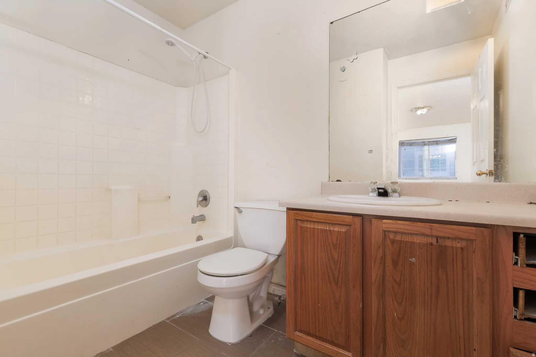 Full bath with vanity, shower / tub combination, and dark tile patterned floors