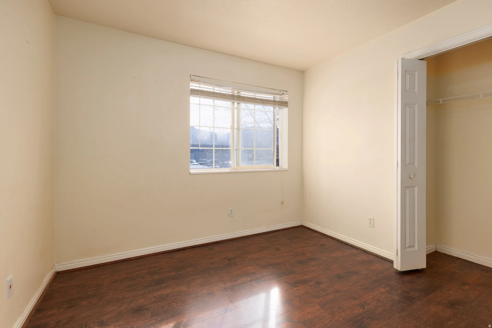 Unfurnished bedroom featuring dark wood finished floors and a closet