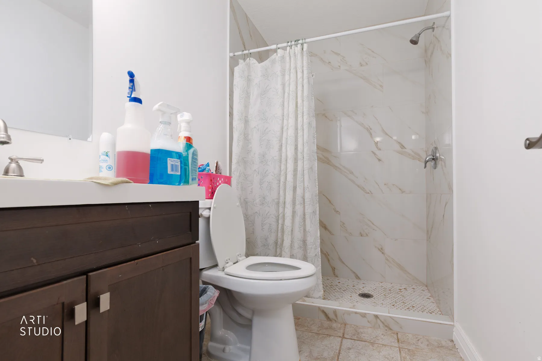 Bathroom featuring vanity and a marble finish shower