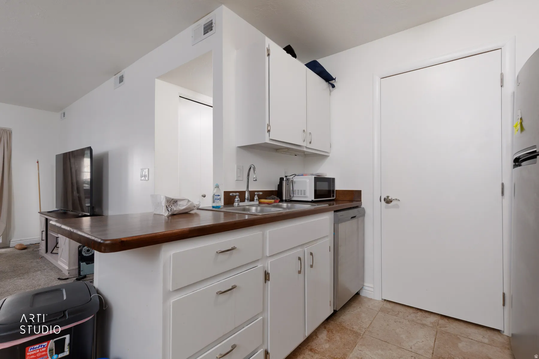 Kitchen with white cabinetry, dark countertops, and stainless steel appliances