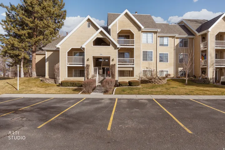 View of apartment building / complex featuring uncovered parking