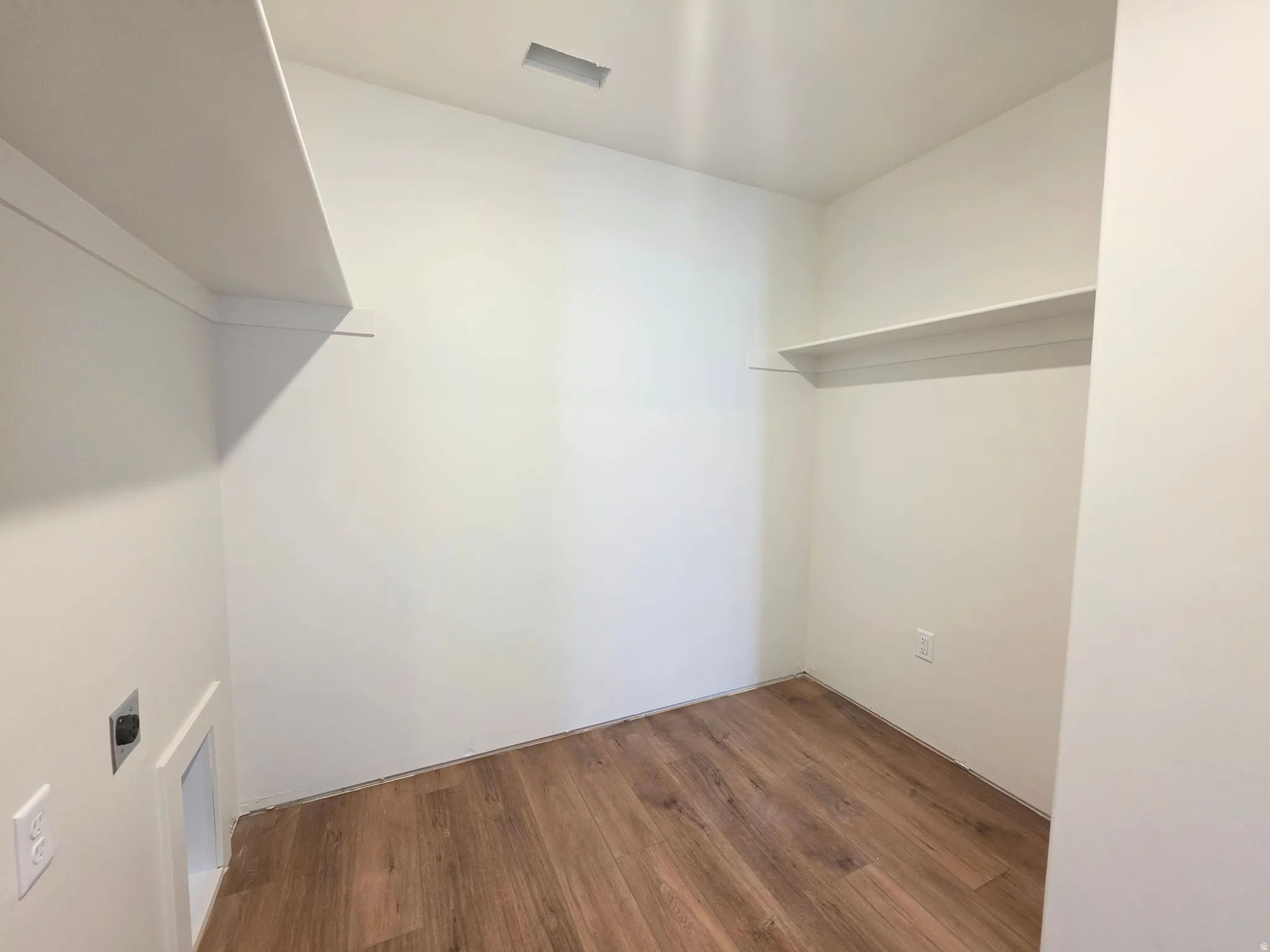 Walk in closet featuring dark wood-style flooring