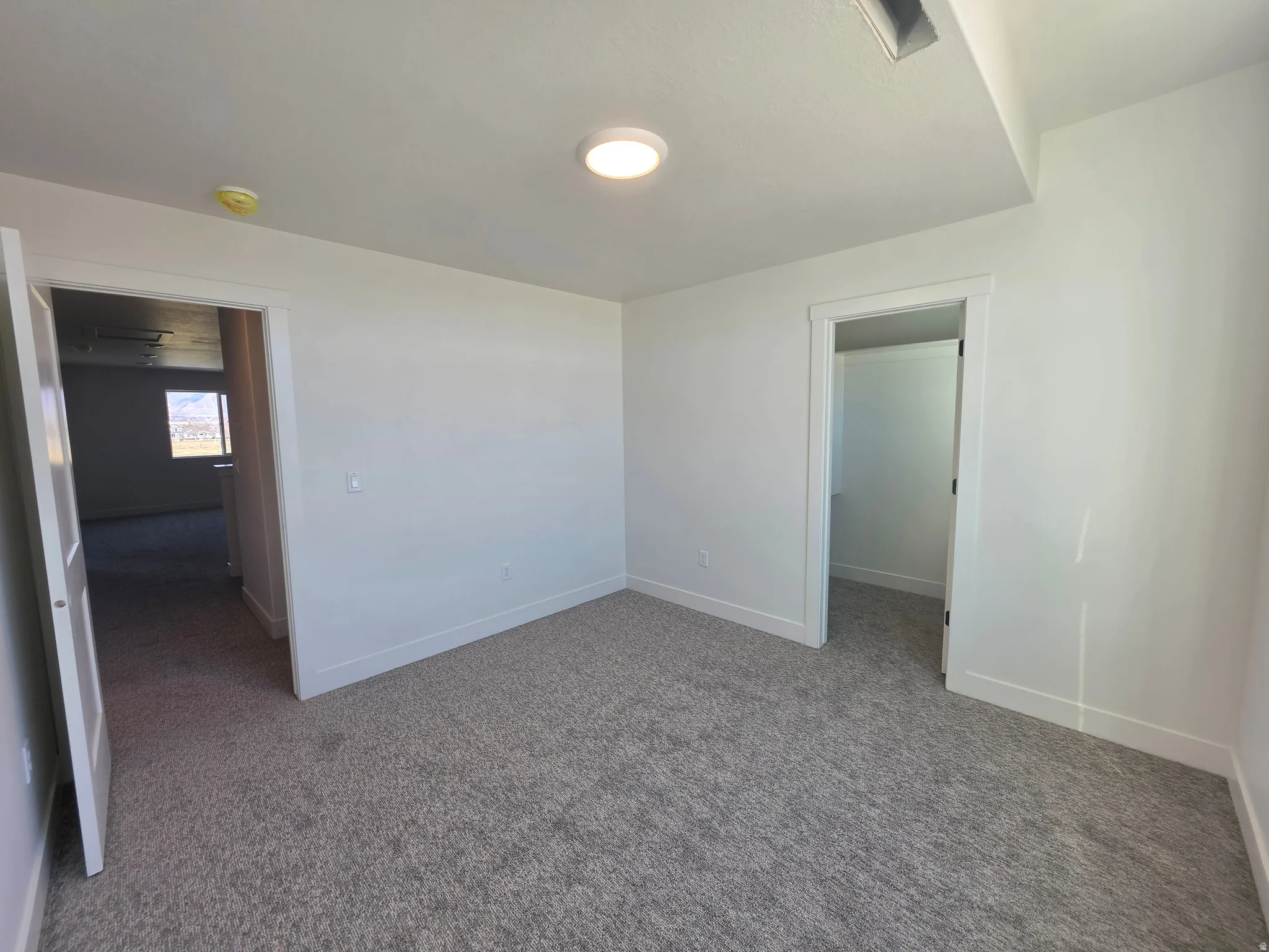 Unfurnished bedroom featuring a spacious closet and dark carpet