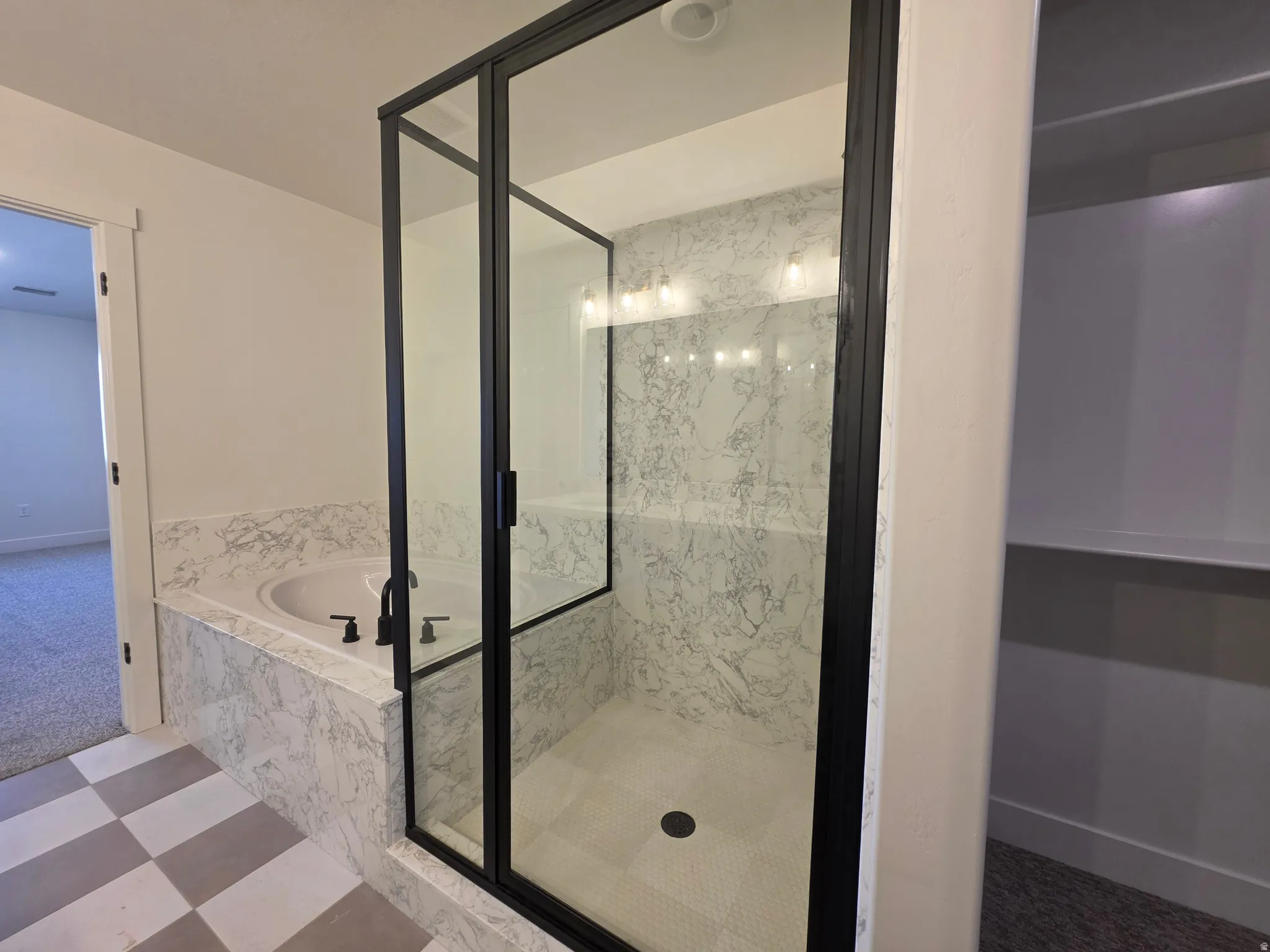 Bathroom featuring a marble finish shower and a bath