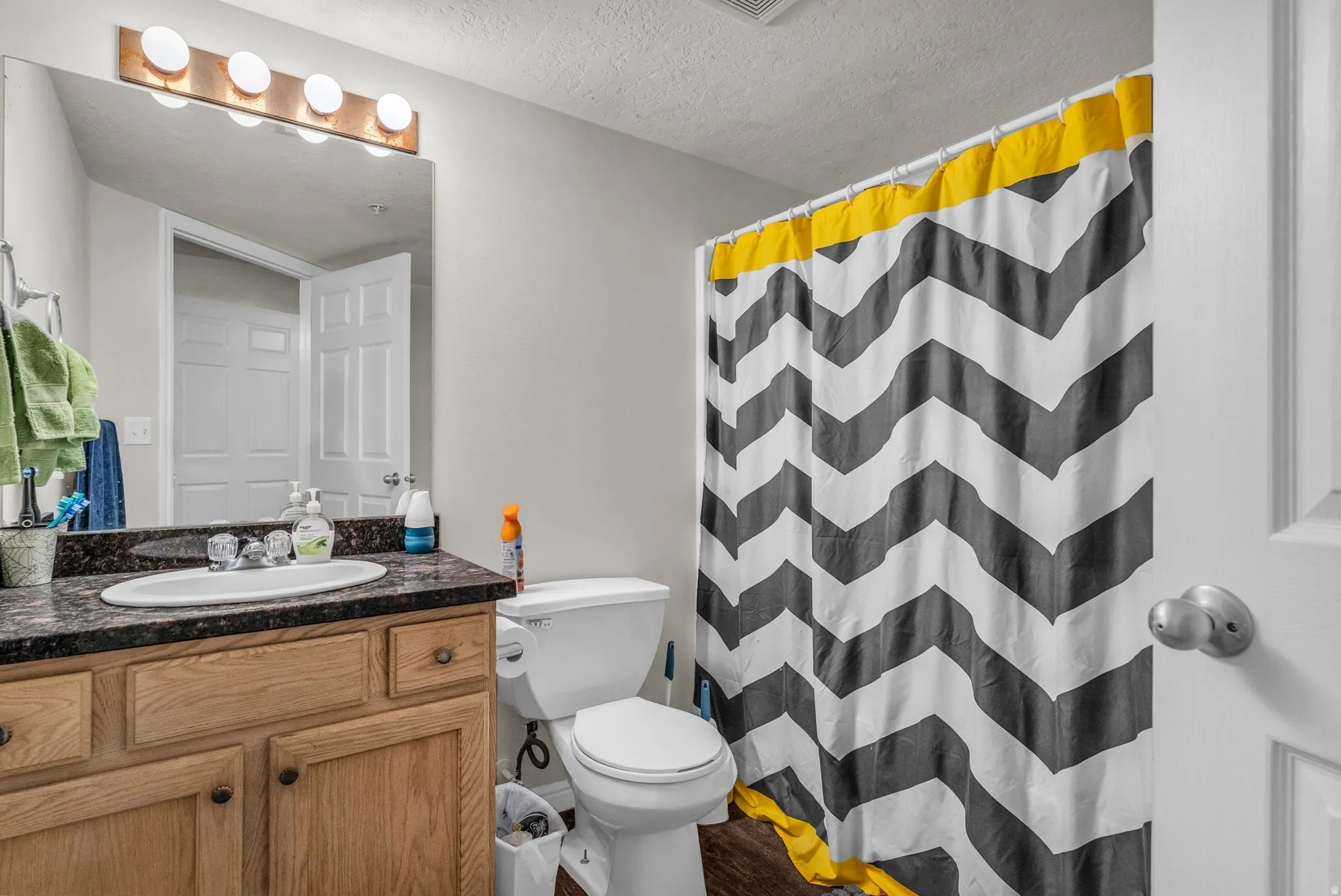 Full bath featuring vanity, a shower with curtain, and a textured ceiling