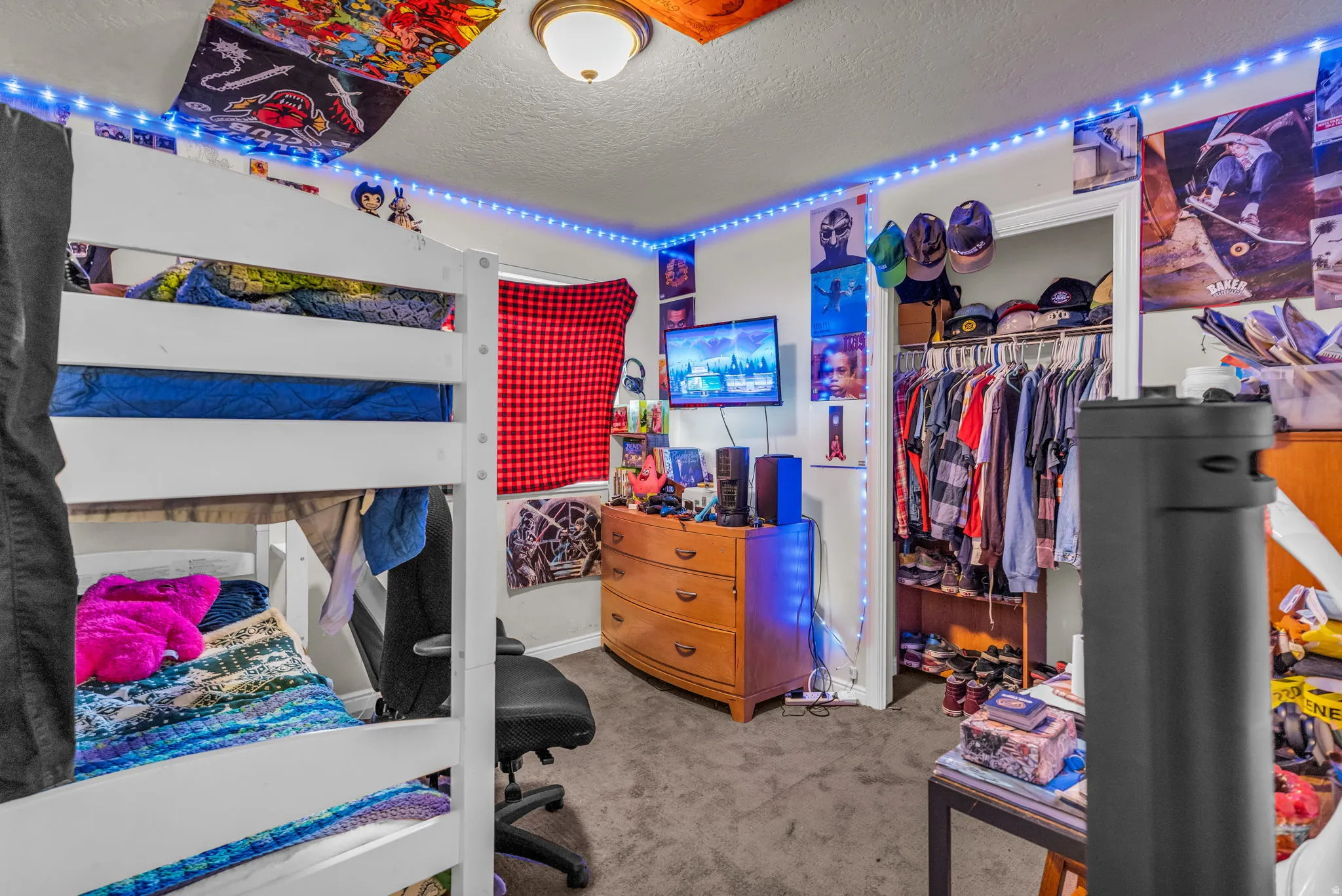 Carpeted bedroom with a textured ceiling and a closet
