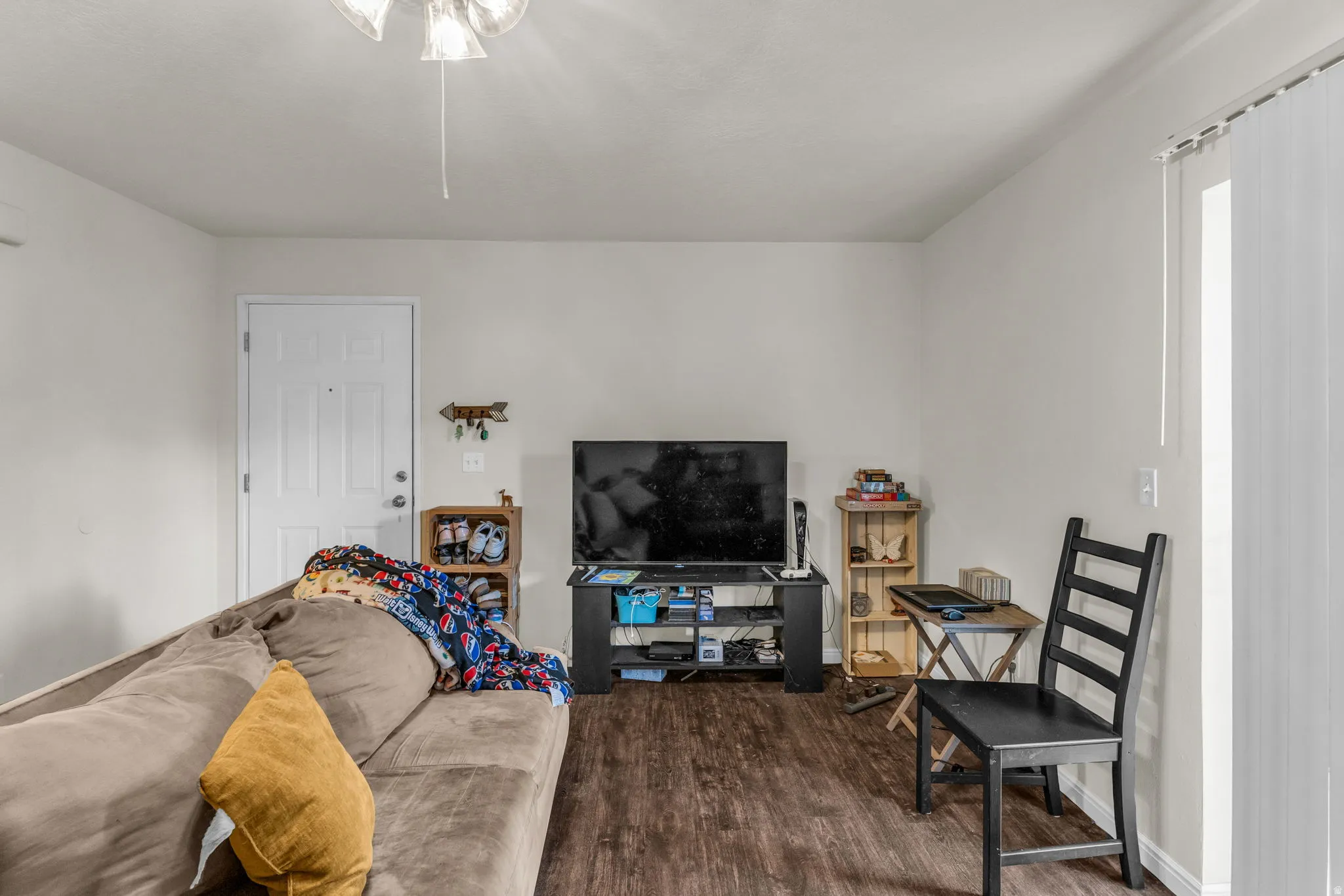 Living area featuring dark wood-style flooring and baseboards