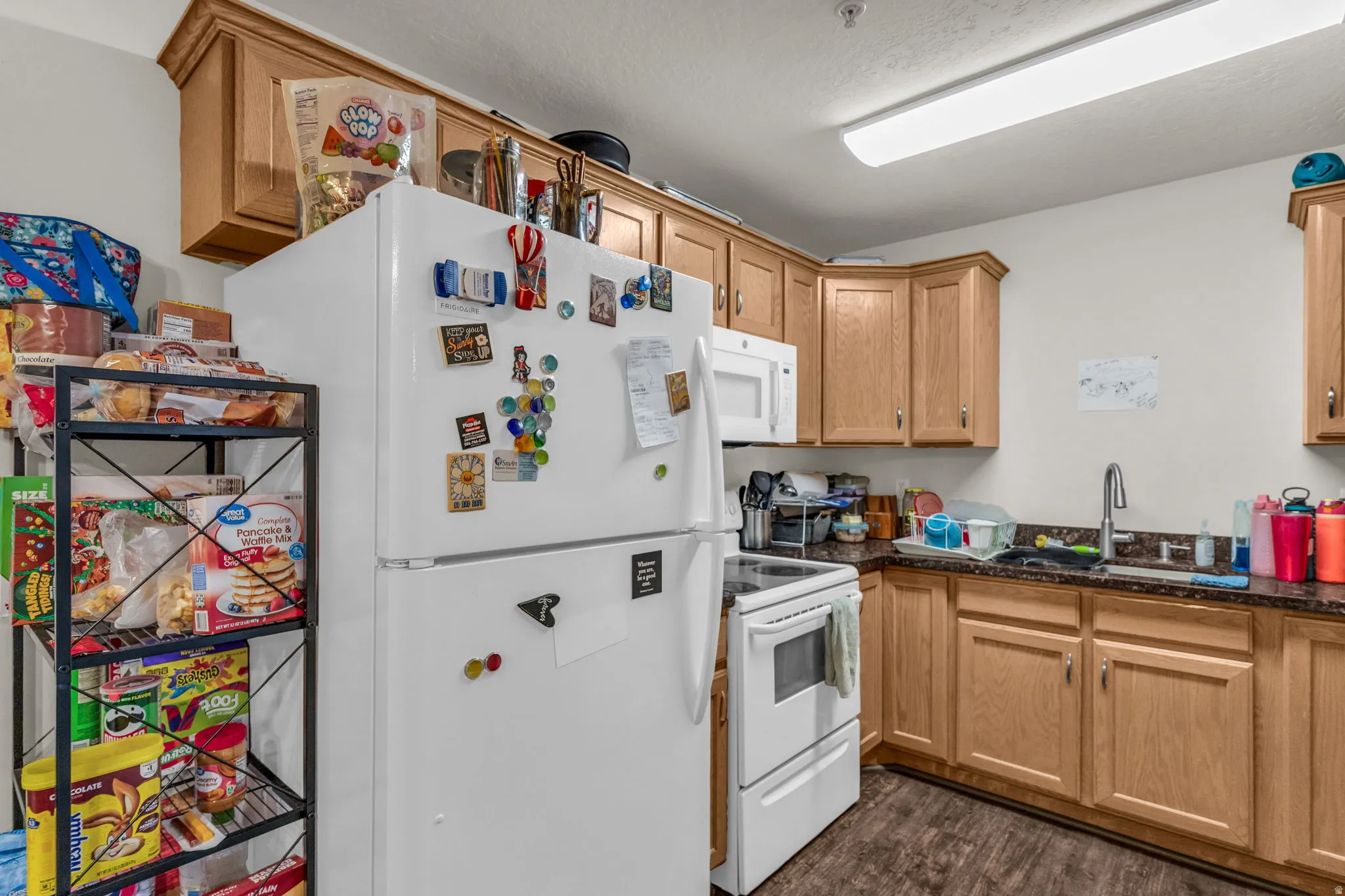 Kitchen featuring white appliances and dark wood-style flooring