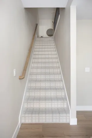 Staircase with baseboards and wood finished floors
