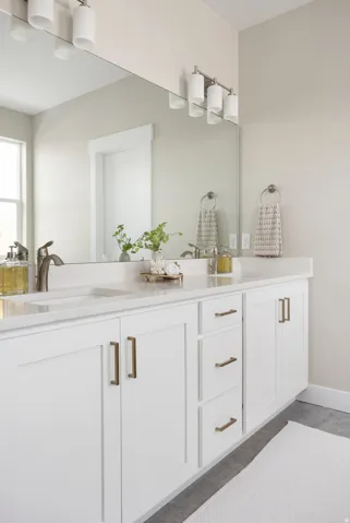 Full bath with double vanity and baseboards
