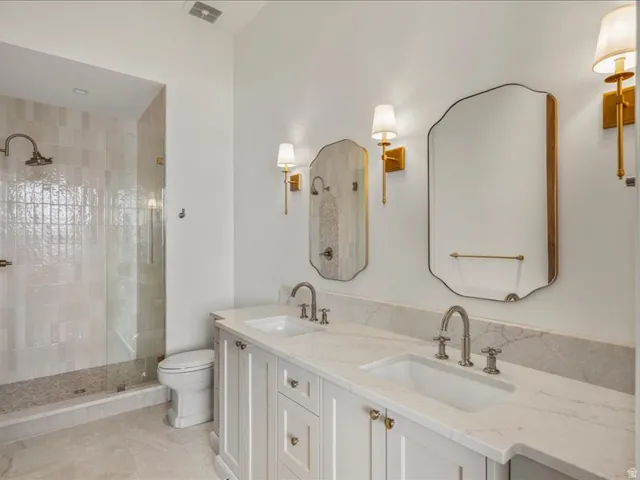 Full bath featuring double vanity and a walk in shower