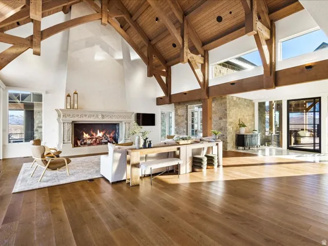 Living area with hardwood / wood-style floors, a fireplace, and a high wooden beamed ceiling