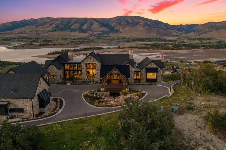 Stone exterior with multiple roof lines, large window expanses, circular driveway, and covered entry