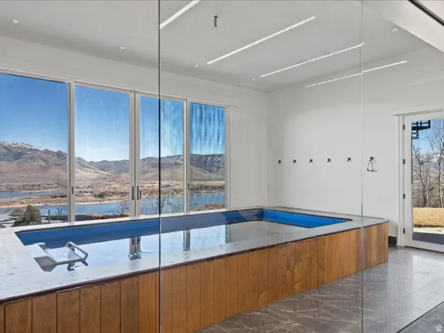 Bathroom featuring a bathtub, a water and mountain view, and dark marble finish flooring