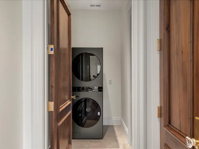 Laundry area featuring baseboards and stacked washer and dryer