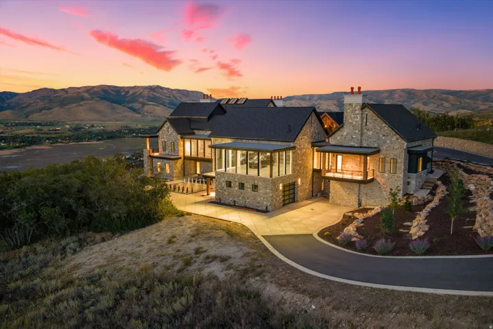Stone exterior with multiple chimneys, featuring a multilevel design and expansive windows