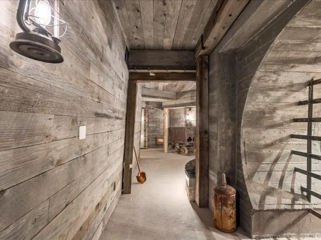 Hall featuring wooden walls, unfinished concrete floors, and wooden ceiling