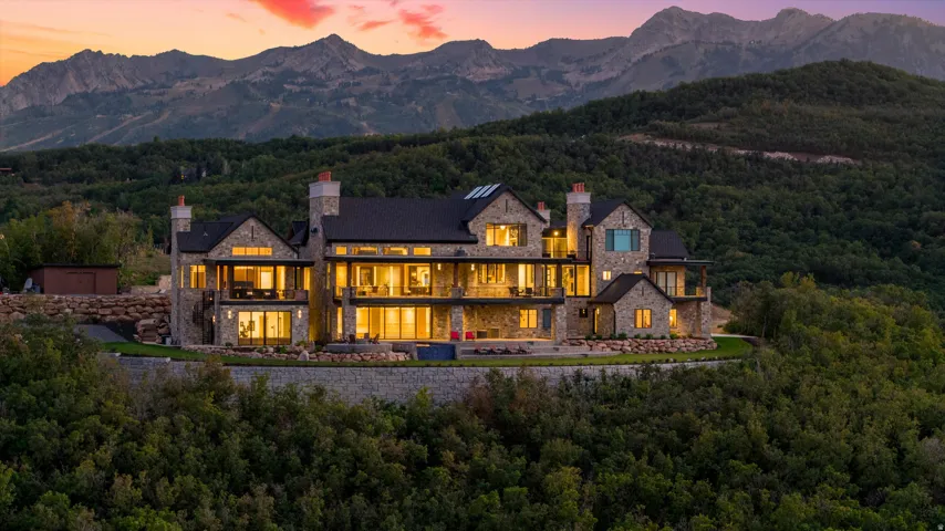 Expansive stone exterior residence with multiple balconies and large windows