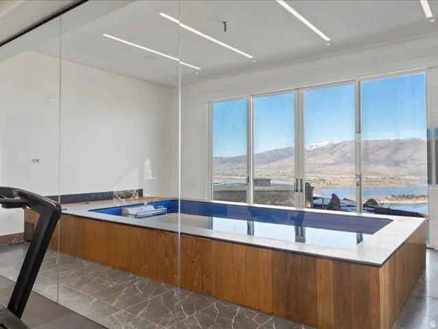 Kitchen featuring modern cabinets, wood finish cabinetry, a mountain view, and light stone countertops