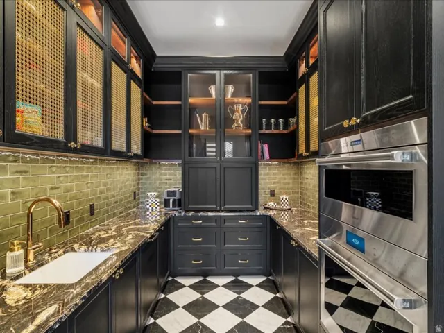 Bar area with open shelves, dark cabinets, and double oven