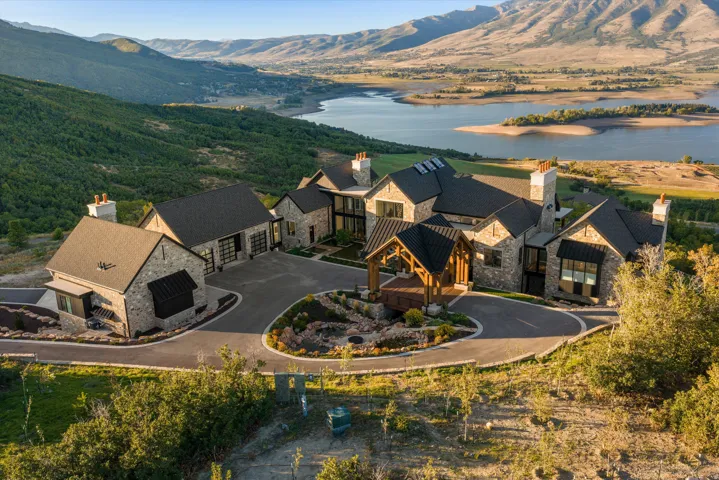 Stone exterior with multiple rooflines, featuring a covered entry, an attached garage, and a detached auxiliary structure