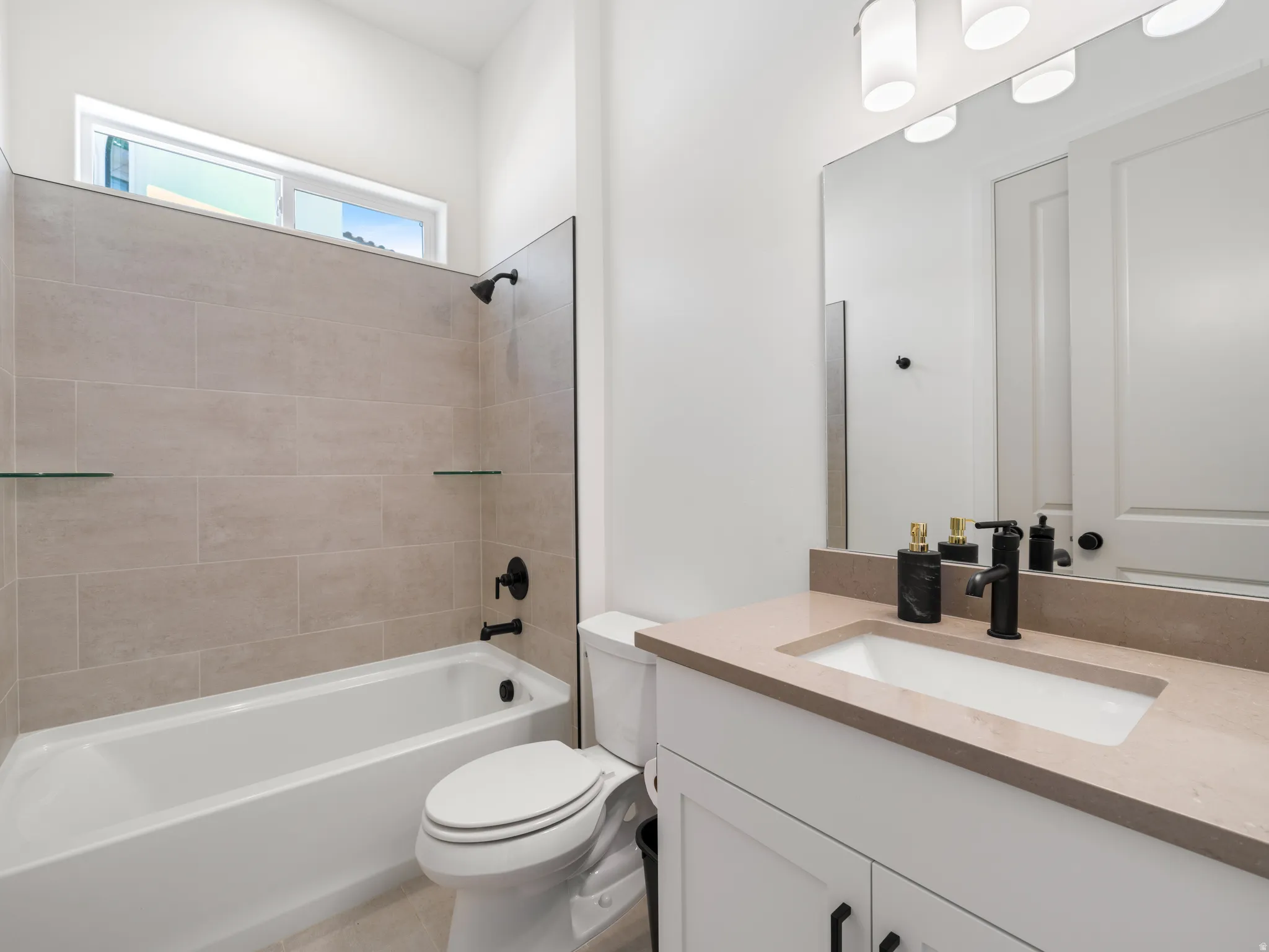 Bathroom featuring a white vanity with a light-toned countertop, an undermount sink, and a matte black faucet