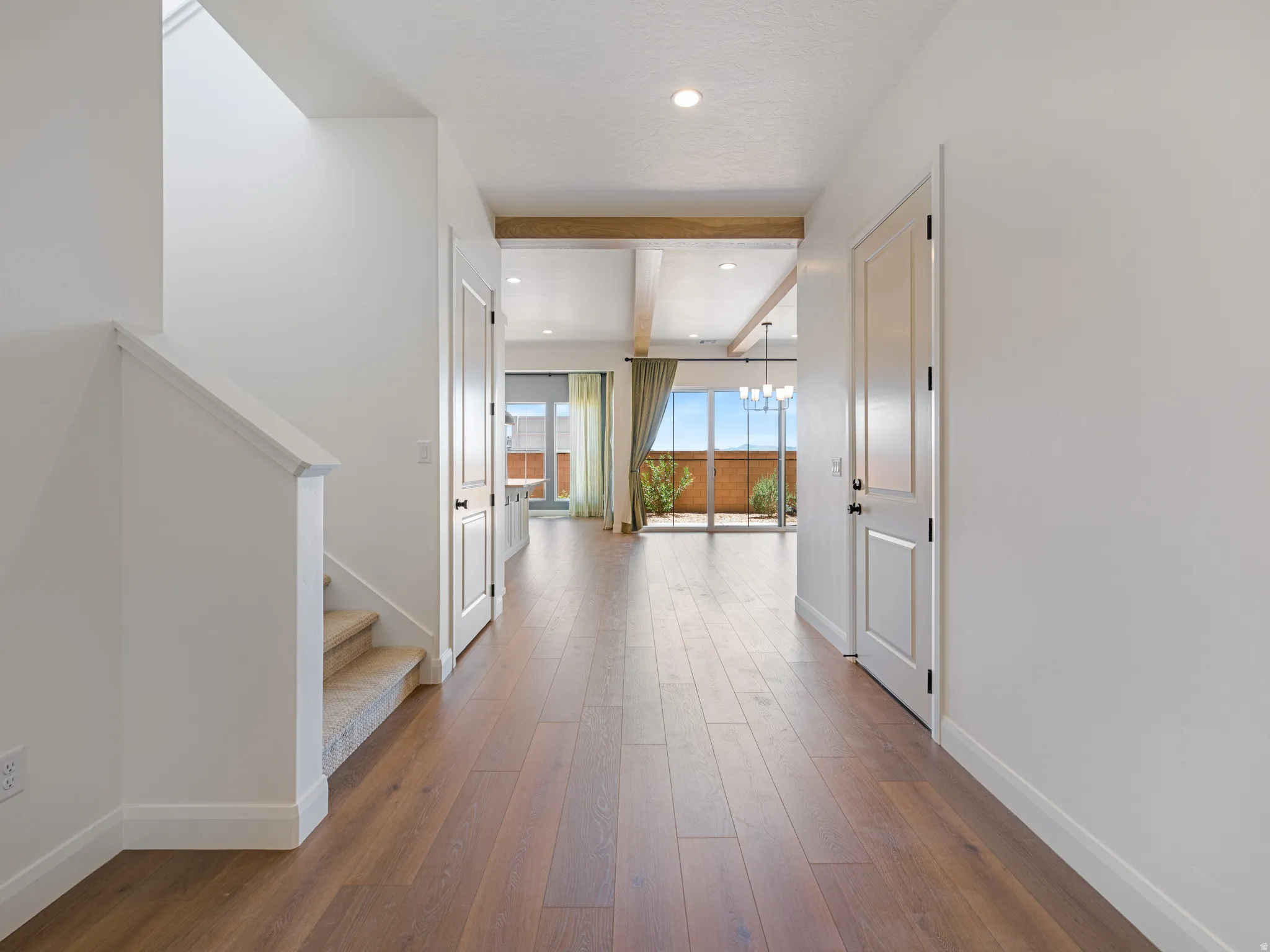 Entryway featuring wood-finish flooring, white paneled doors, and recessed lighting
