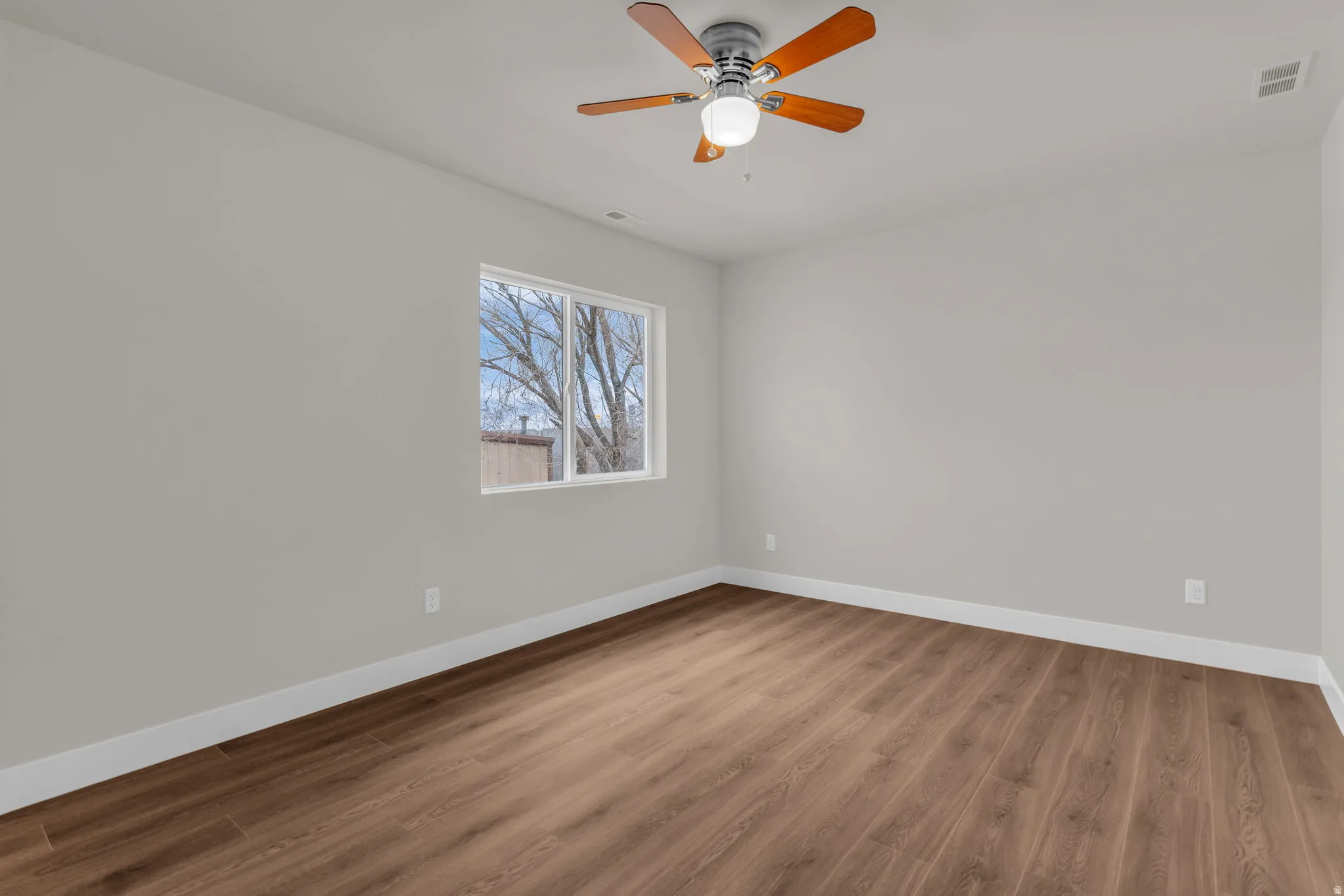 Unfurnished room featuring wood finished floors and a ceiling fan