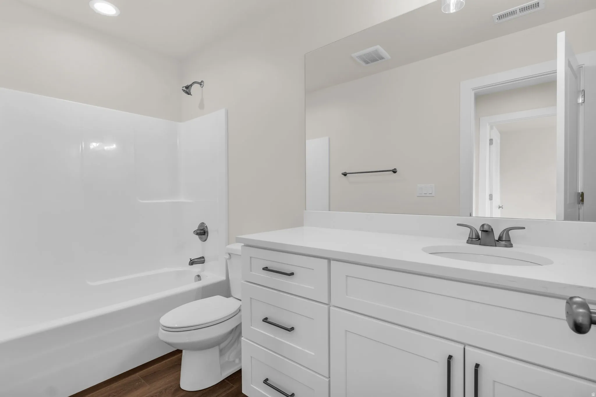 Full bathroom with bathing tub / shower combination, vanity, and dark wood finished floors