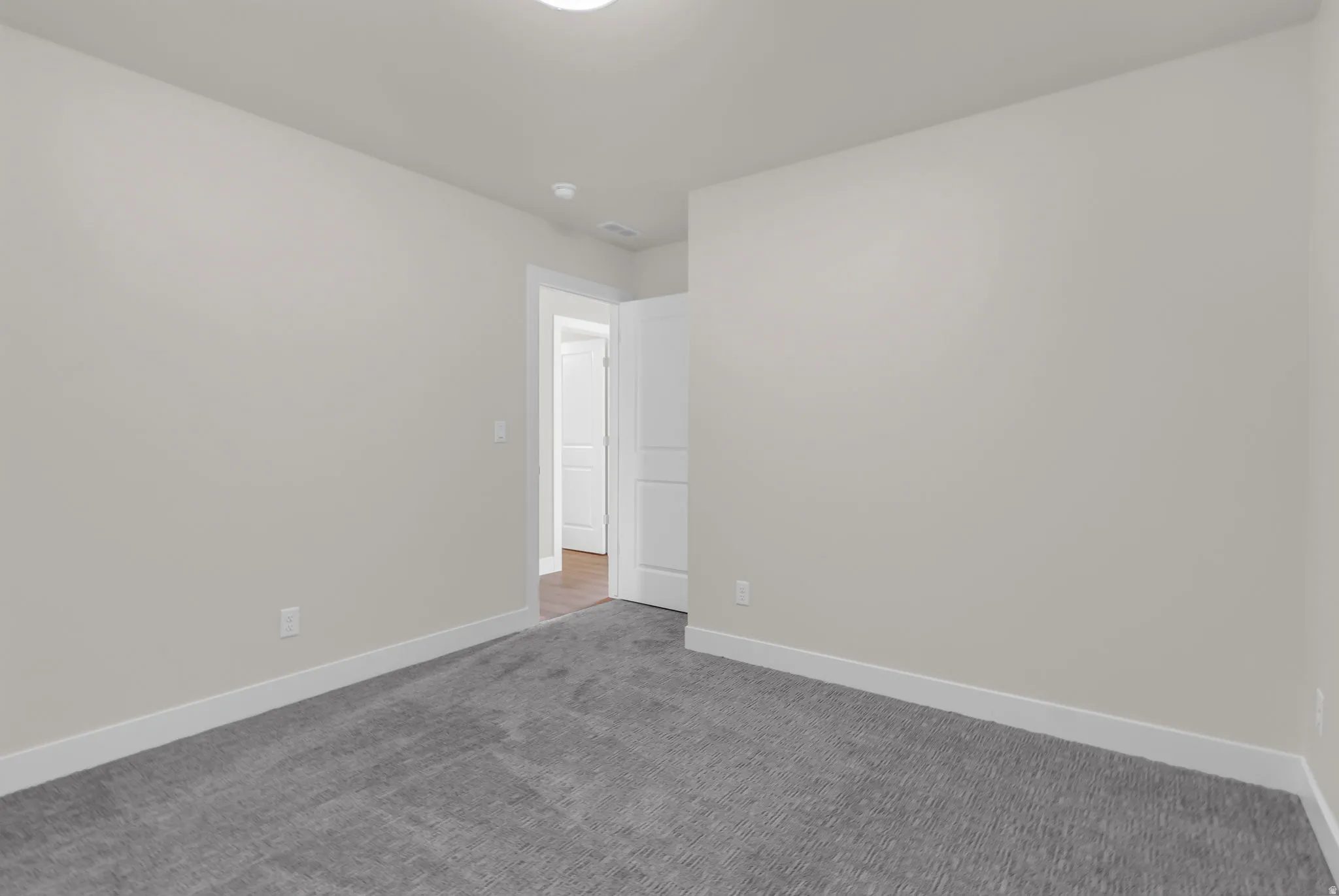 Empty room featuring baseboards and carpet floors