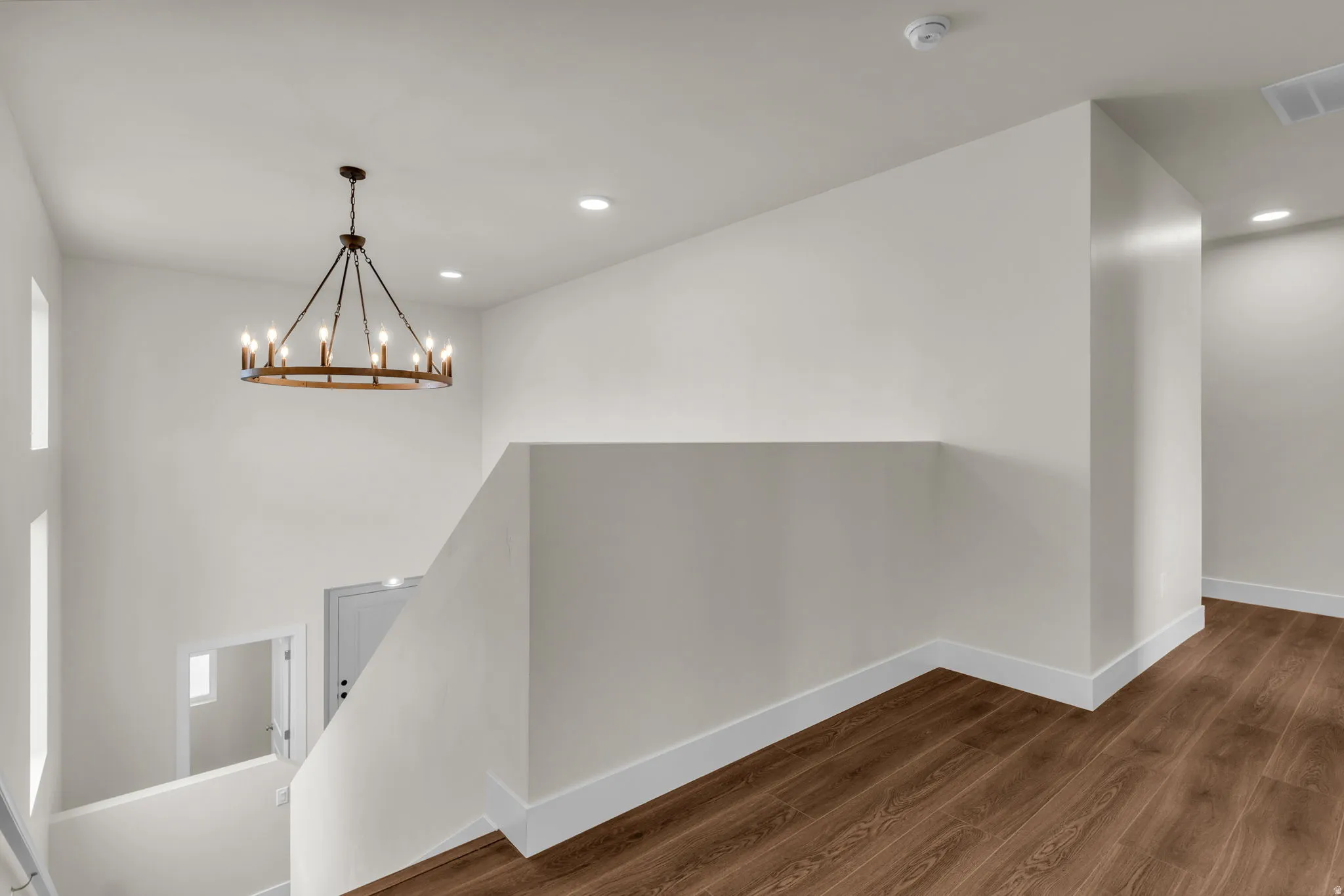 Hall featuring dark wood-type flooring and hanging lights
