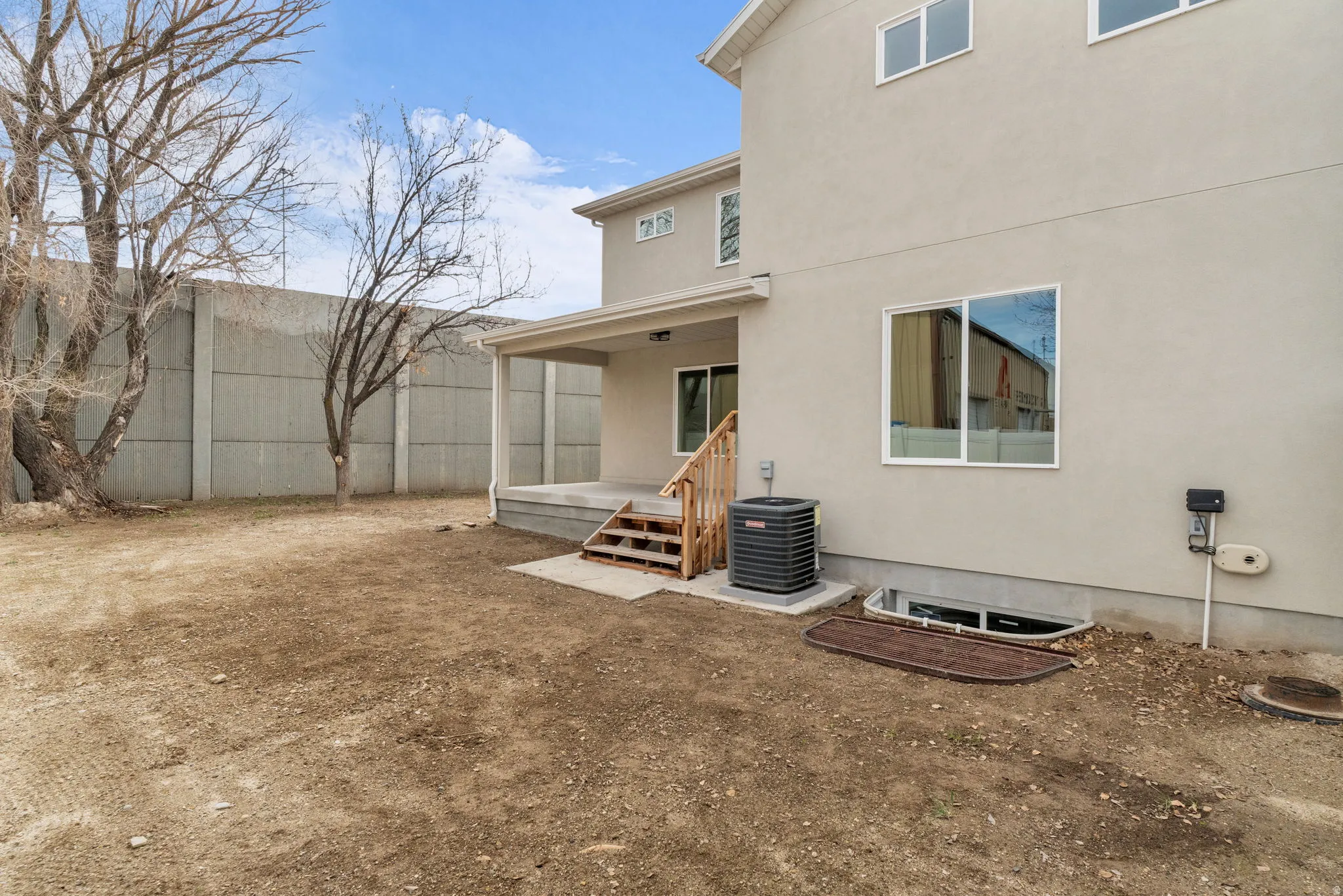 Back of house with a patio area and stucco siding
