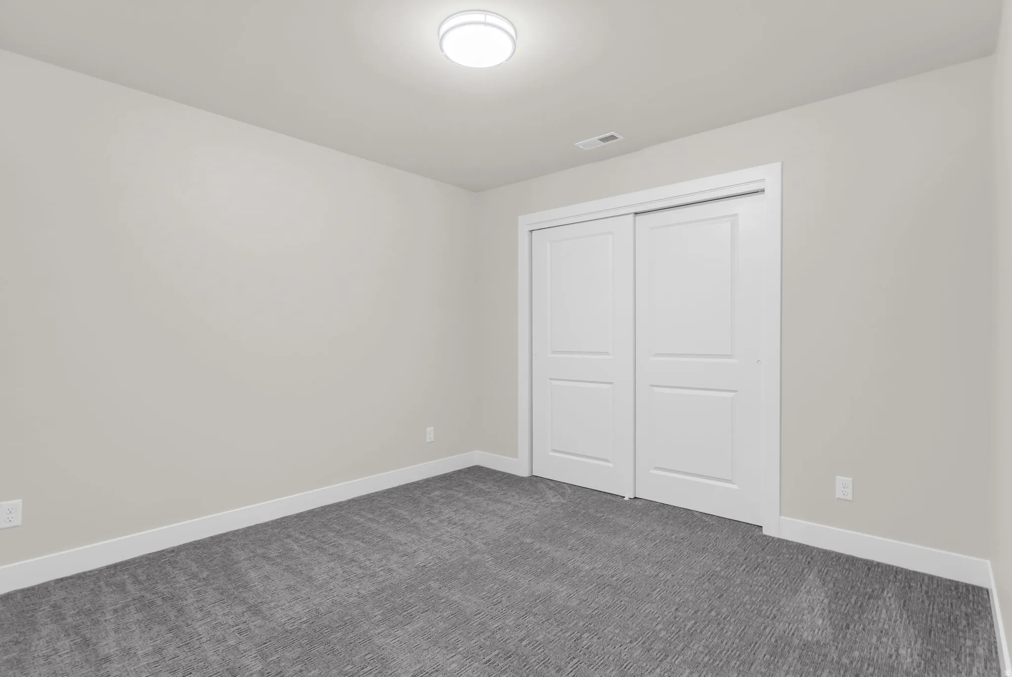 Unfurnished bedroom with dark carpet and a closet