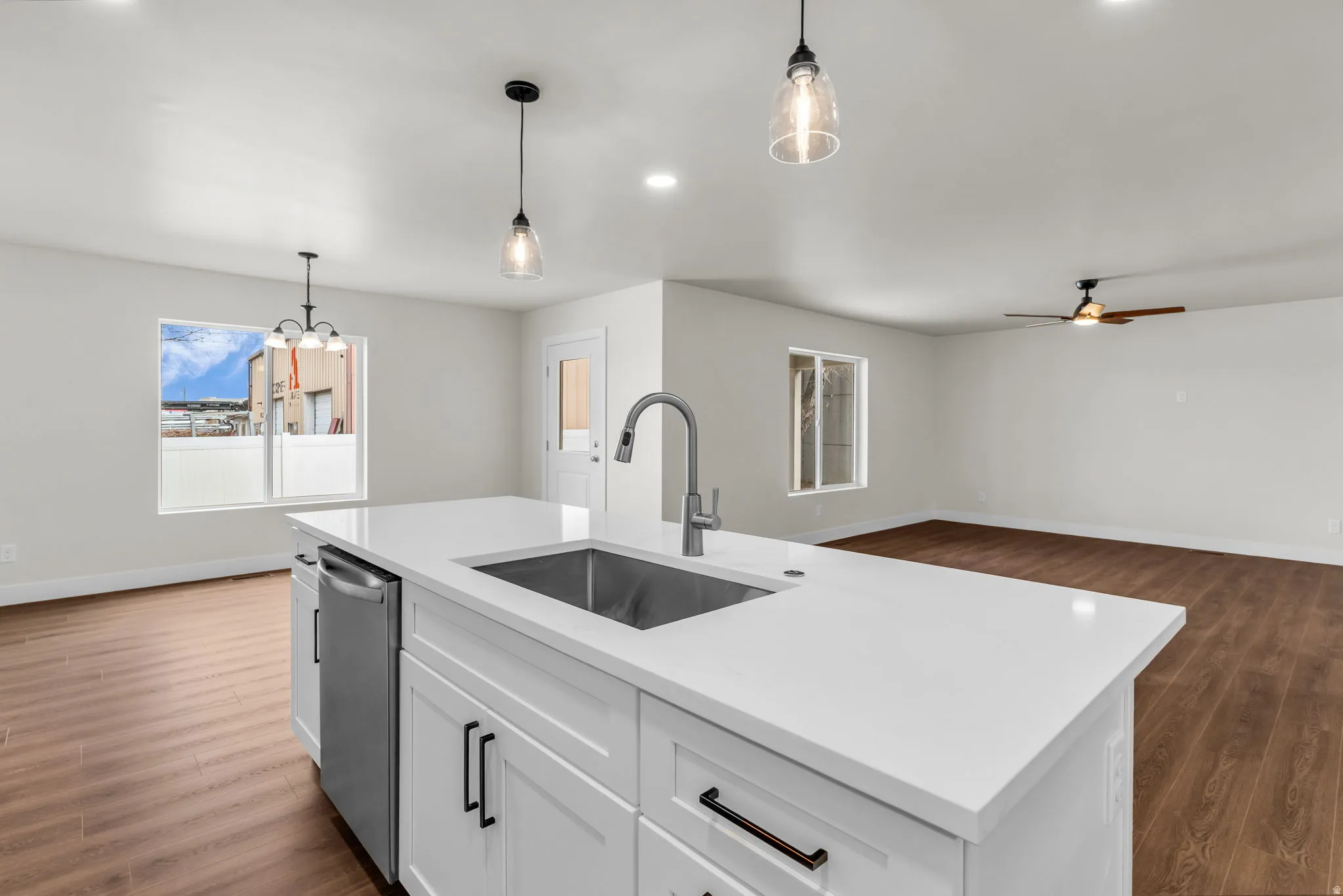 Kitchen featuring dark wood finished floors, white cabinetry, ceiling fan, open floor plan, and dishwasher
