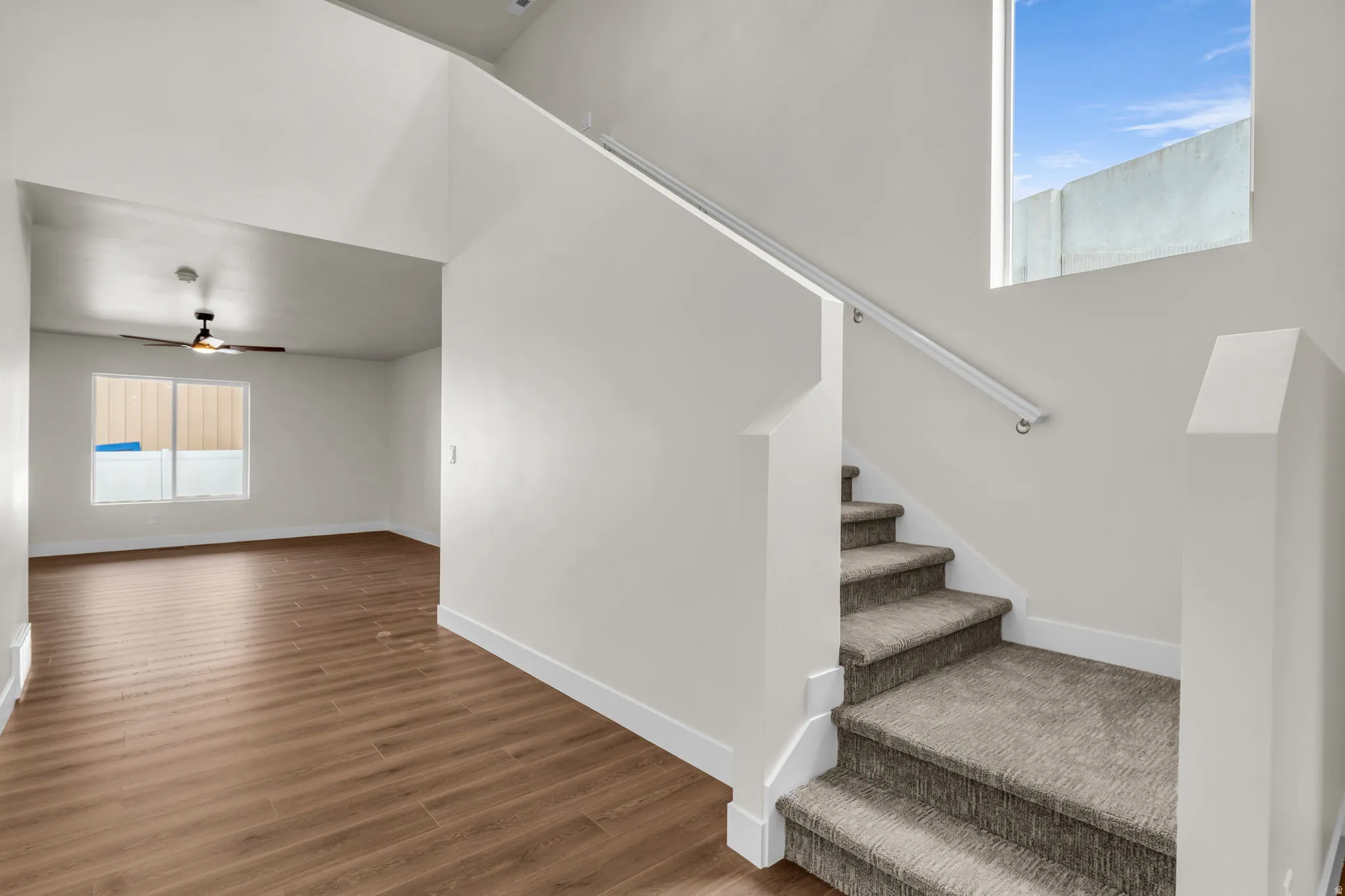 Staircase with ceiling fan and wood finished floors