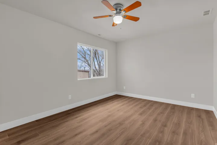 Unfurnished room featuring wood finished floors and a ceiling fan