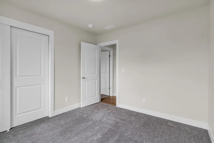 Unfurnished bedroom featuring carpet flooring and a closet