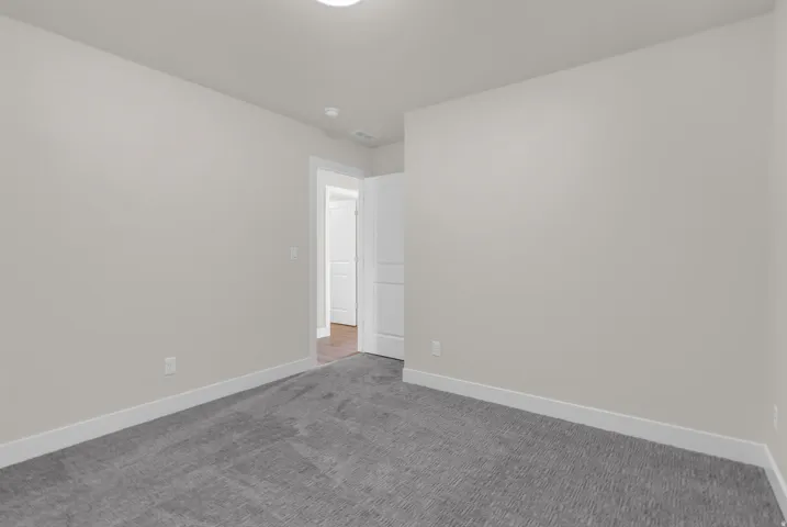 Empty room featuring baseboards and carpet floors