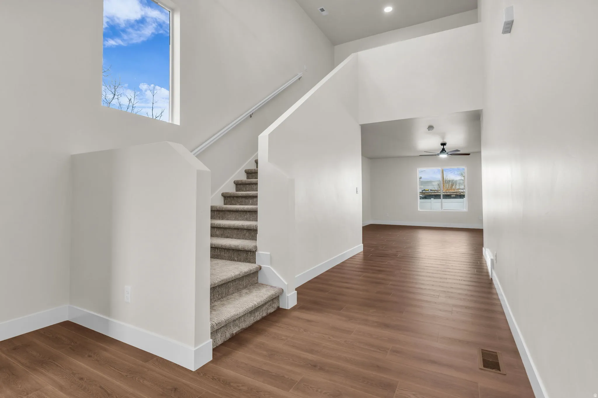Stairway with a high ceiling and wood finished floors