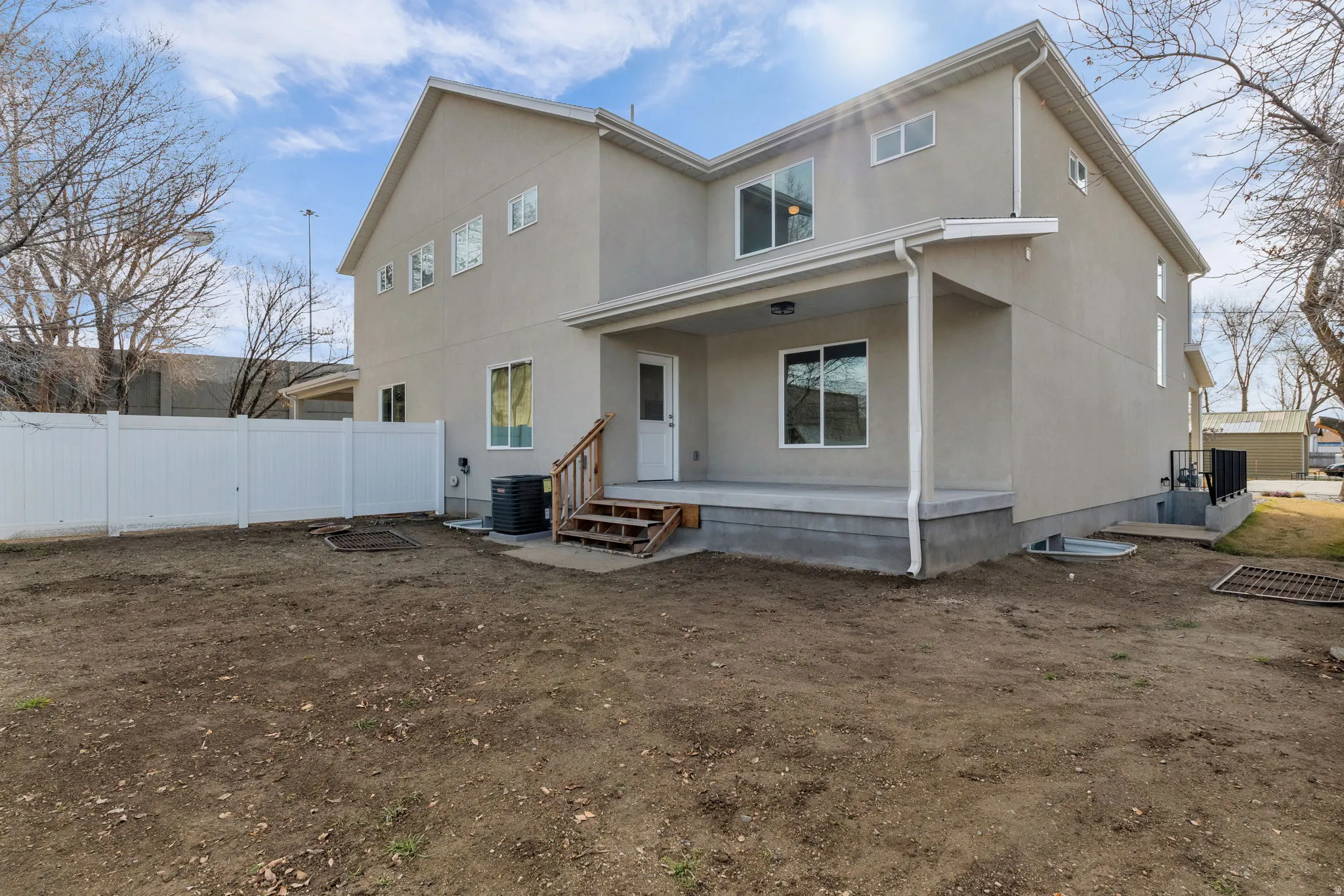 Back of house with stucco siding, a patio area, and a porch