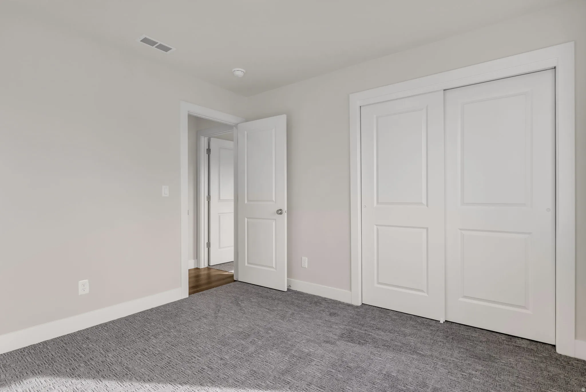 Unfurnished bedroom featuring carpet flooring and a closet