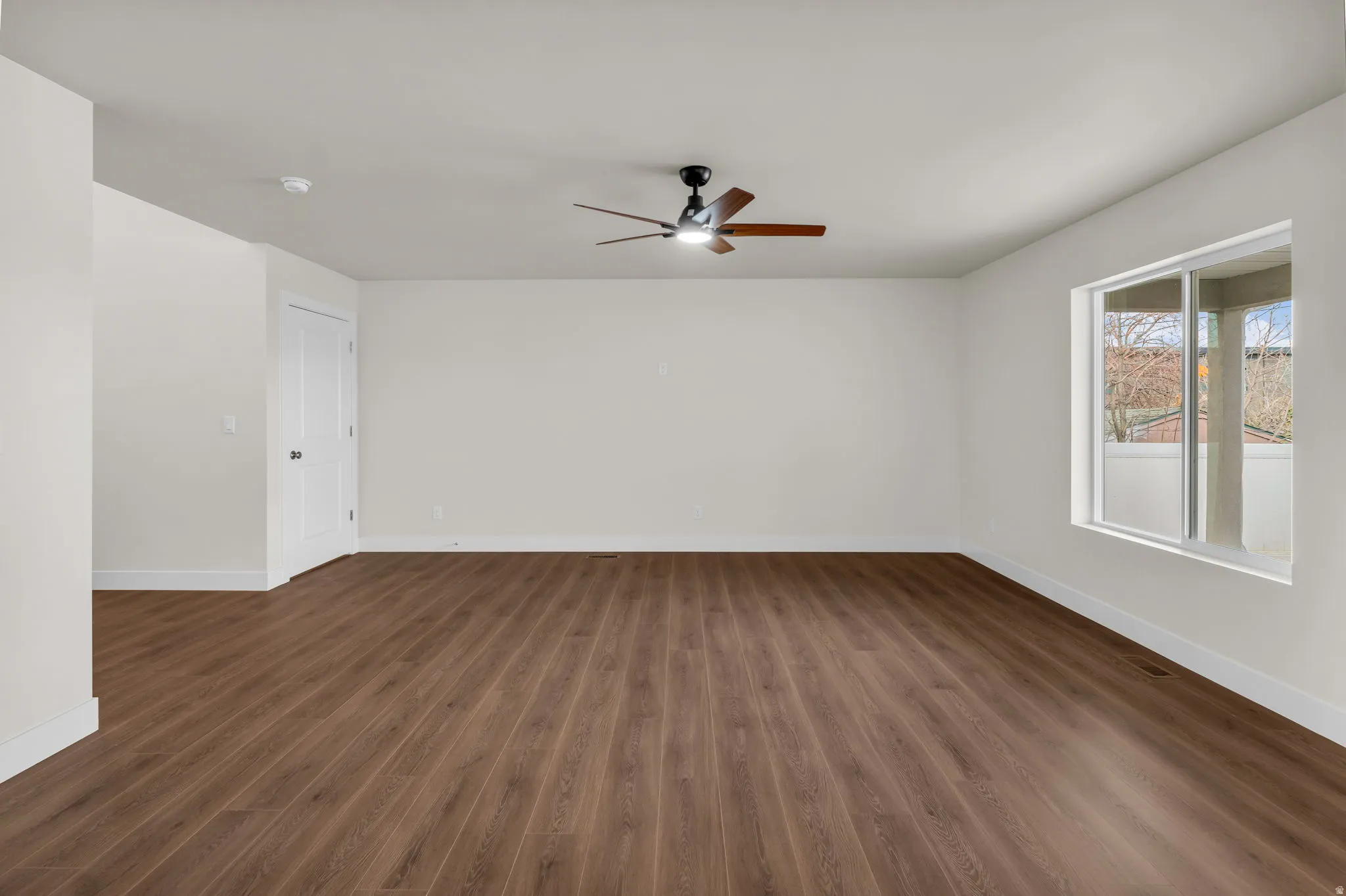 Spare room with dark wood-style floors and ceiling fan