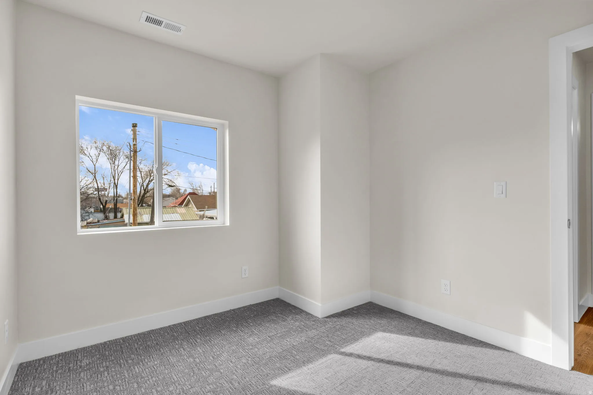 Carpeted empty room featuring baseboards