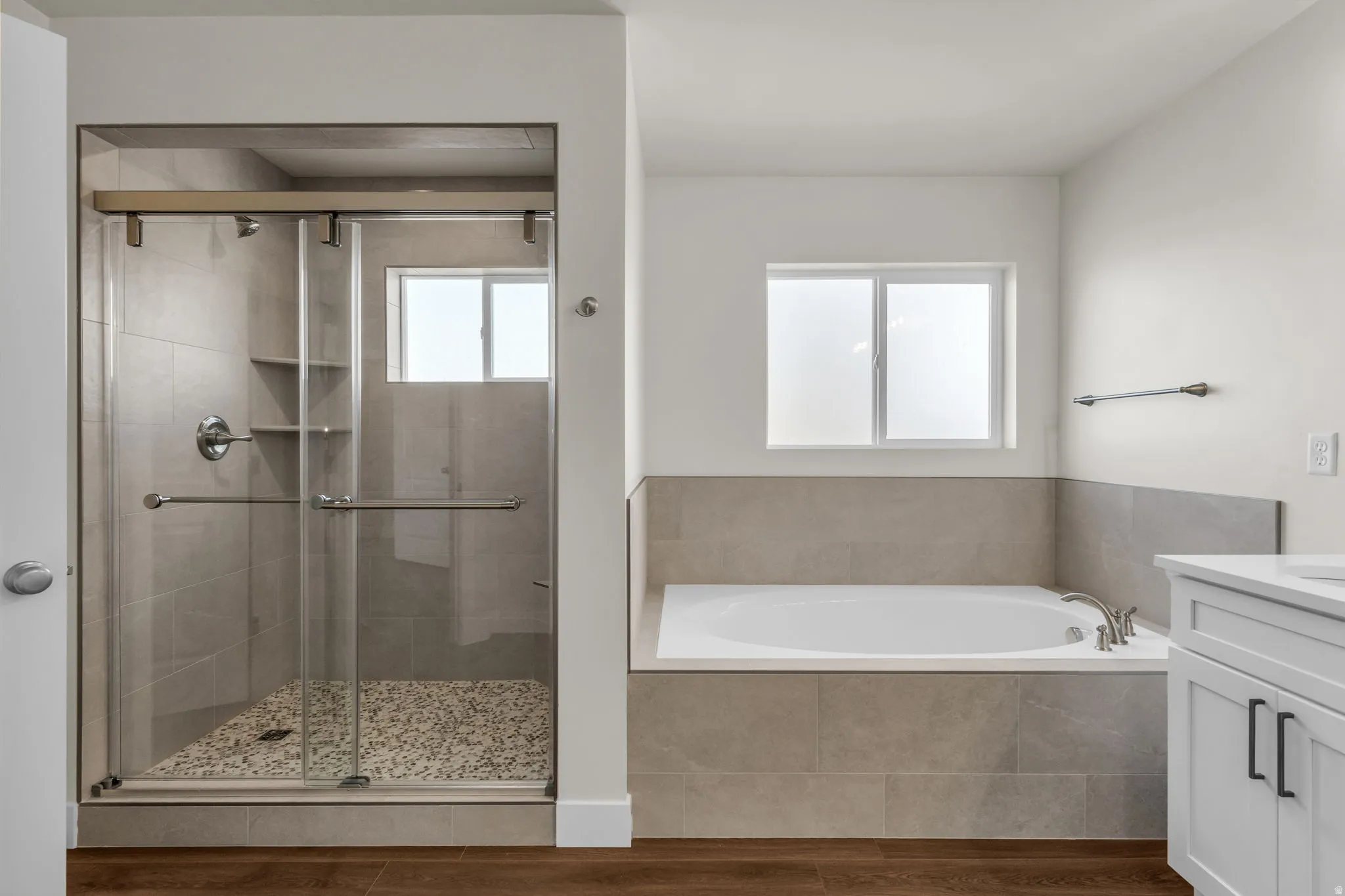 Full bathroom with vanity, a shower stall, a bath, and wood finished floors