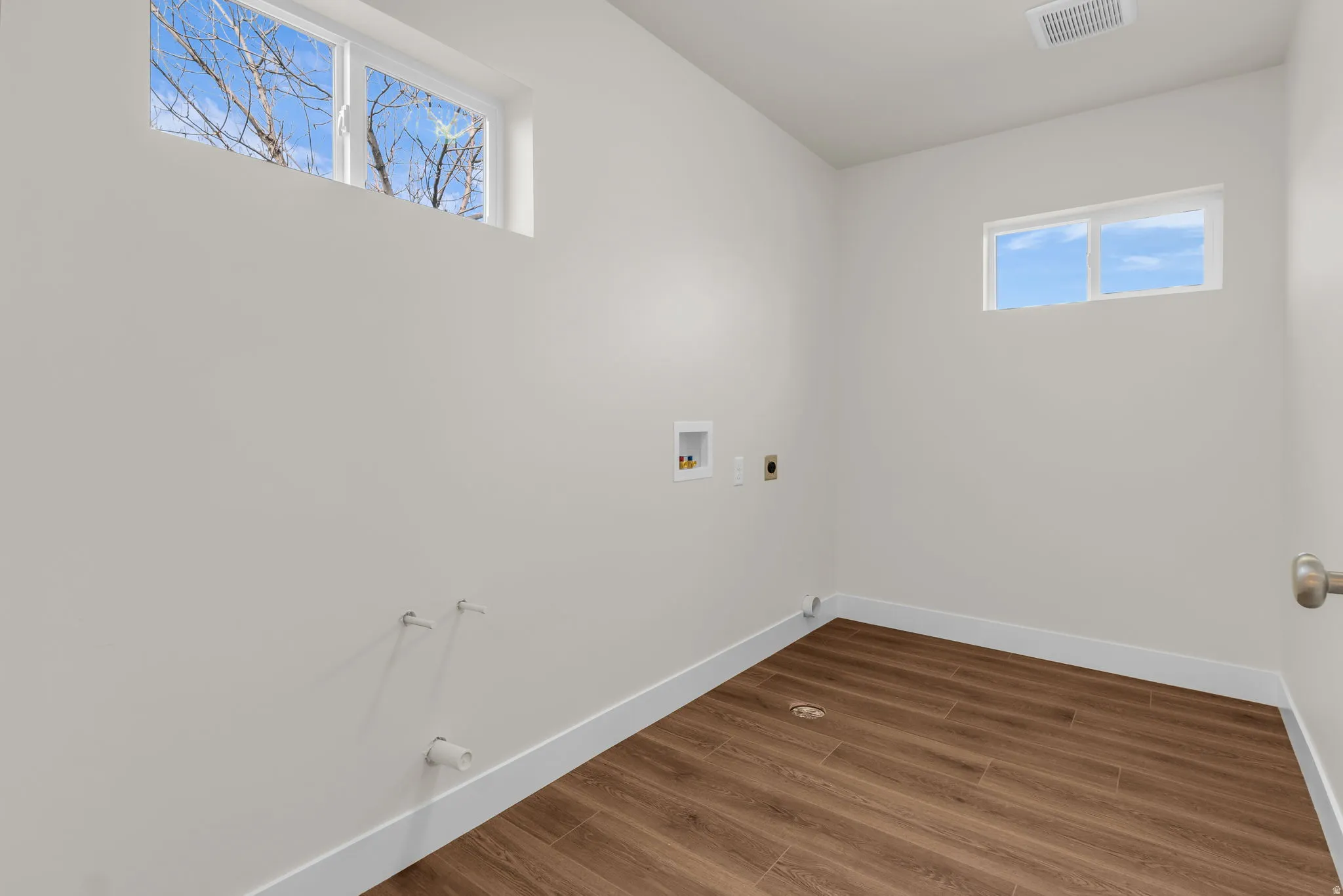 Laundry area with washer hookup, wood finished floors, gas dryer hookup, and electric dryer hookup