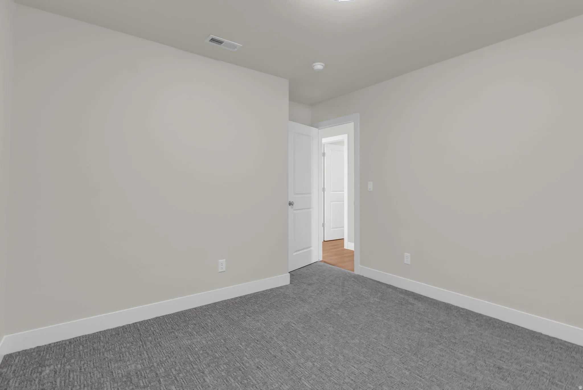 Empty room with carpet flooring and baseboards